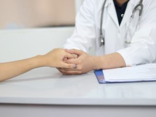 Docteur tenant la main d'une patiente