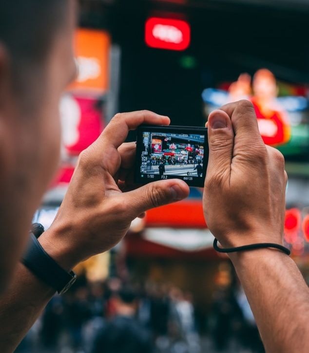 Un chinois prenant une photo avec son smartphone.