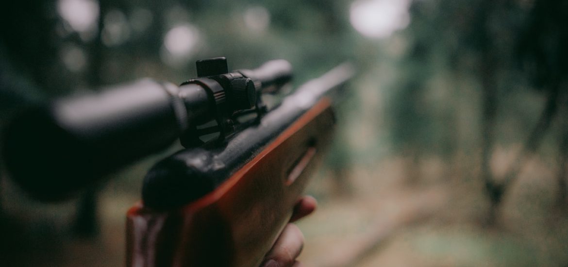 Un chasseur regardant dans le viseur de son fusil.
